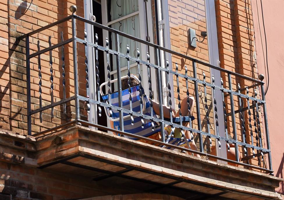 Un joven aprovecha su minúsculo balcón para tomar el sol en la tercera semana de confinamiento