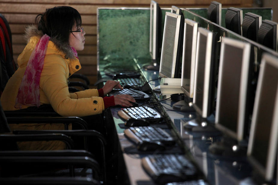 FILE PHOTO: A woman uses a computer in an internet cafe in Shanghai