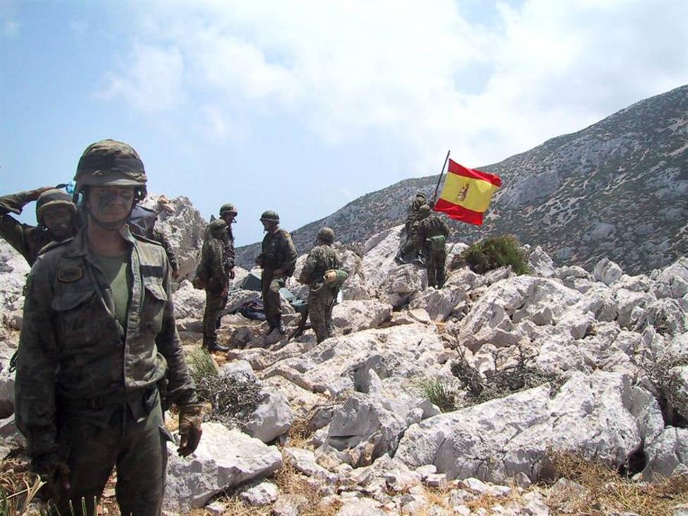 Soldados españoles junto a la bandera de España clavada en Perejil