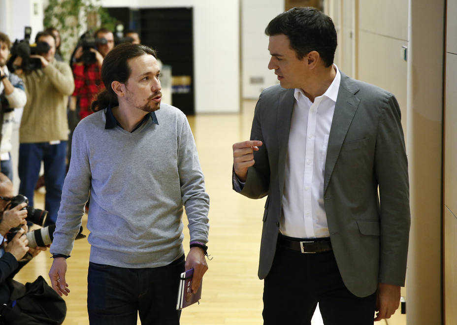 Socialists leader Sanchez and Podemos leader Iglesias talk as they arrive for their meeting at the Spanish Parliament in Madrid