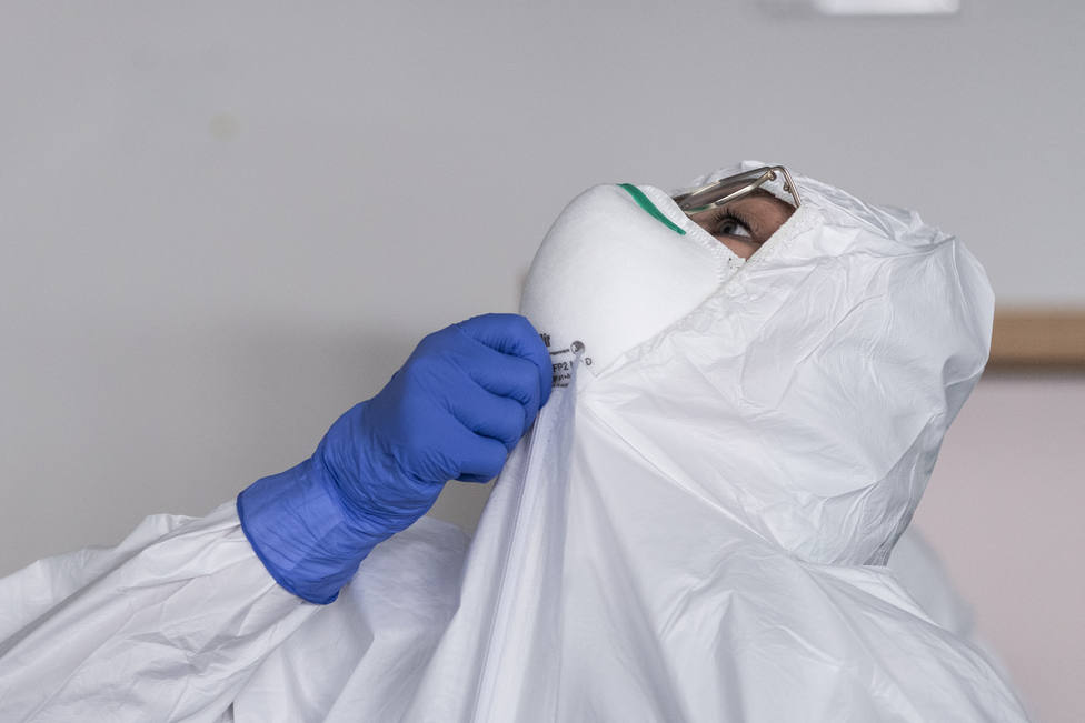 Un sanitario se ajusta su equipo de protección indivual - FOTO: Europa Press / Marco Alpozzi