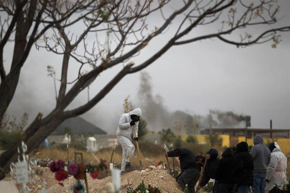 Empleados funerarios sepultan a personas fallecidas por la covid-19 este martes, en México