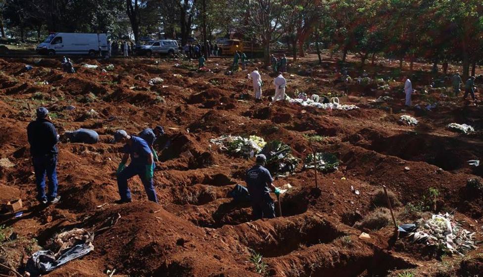 Trabajadores enterrando víctimas mortales de la pandemia COVID-19, en el cementerio de Vila Formosa, en Brasil