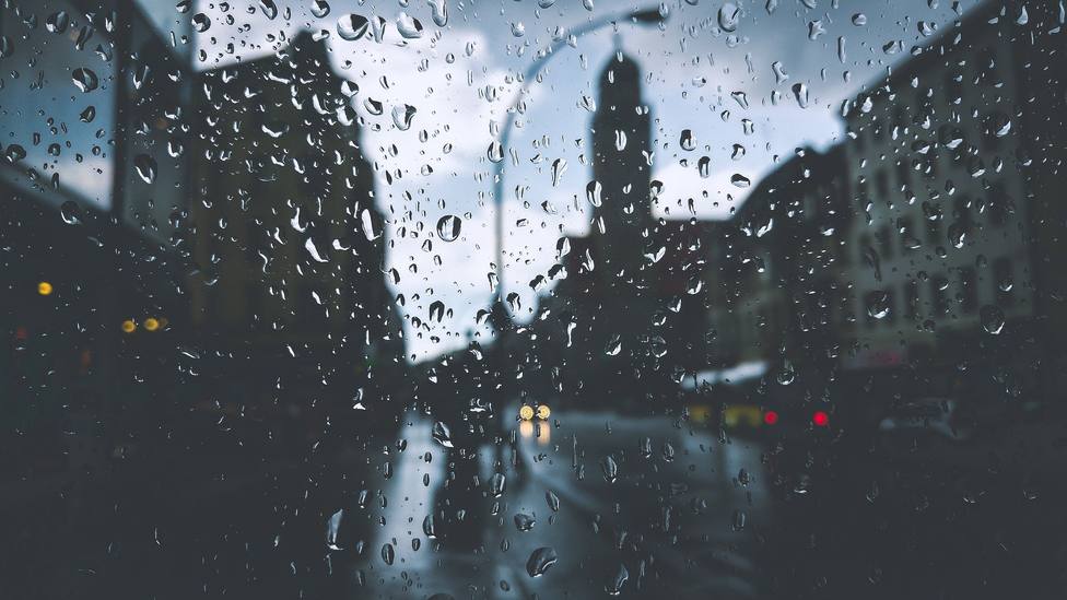 Lluvia a través de la ventana en una ciudad
