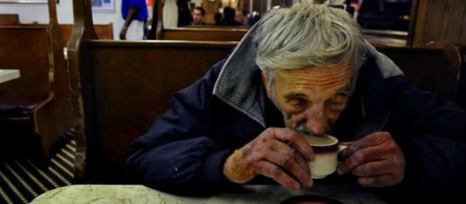 Un mendigo disfruta de un café que otro cliente ha dejado pagado. www.cafespendientes.es