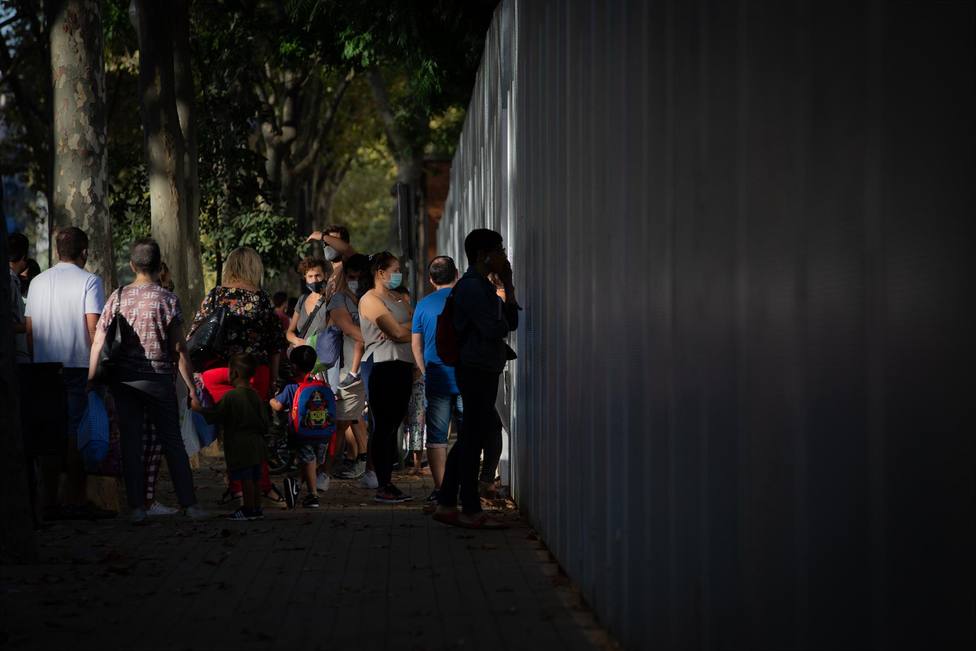 Padres y alumnos esperan a las puertas de un colegio en Barcelona