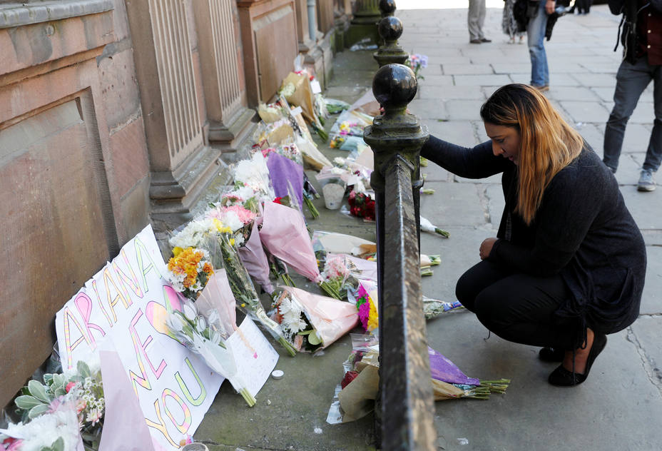A woman lays flowers for the victims of the Manchester Arena attack, in central Manchester