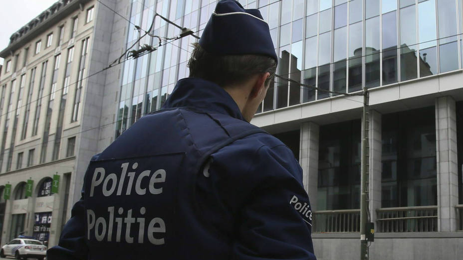 Un policía monta guardia delante de un edificio de la Policía Federal en Bruselas (Bélgica)