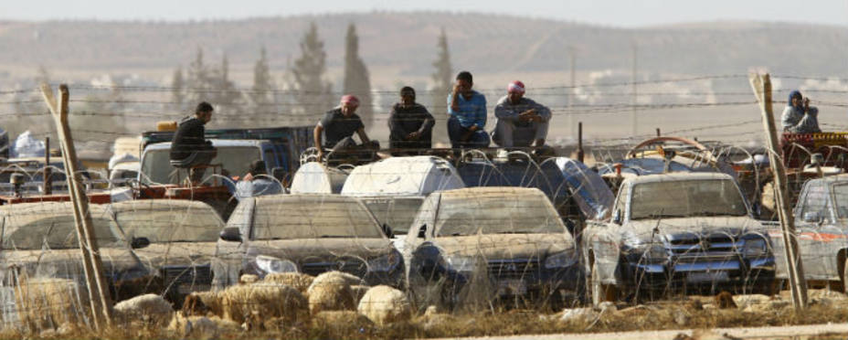 Refugiados kurdos sirios se sientan en sus coches en el lado sirio de la frontera turco-siria cerca de la ciudad de la ciudad de Suru. Reuters