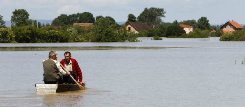 Dos hombres reman en la ciudad bosnia de Vojskova, afectada por las inundaciones. REUTERS