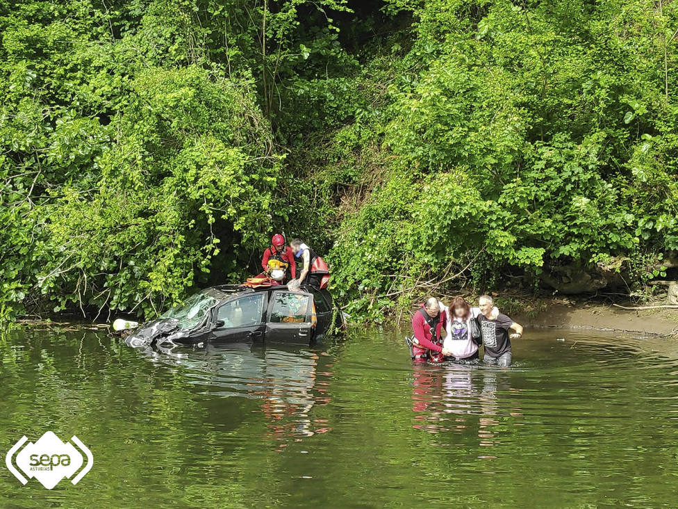 Los bomberos rescatan a los ocupantes del turismo que cayó al río