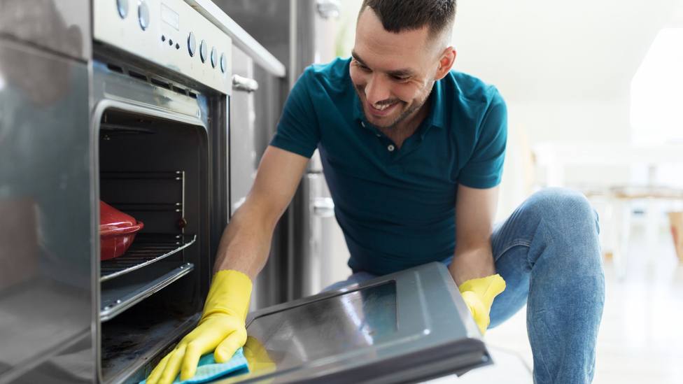 Una persona limpiando un horno
