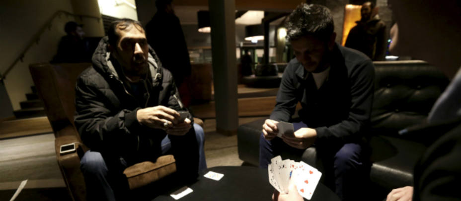 Refugiados juegan a las cartas en un campamento en Suecia. REUTERS
