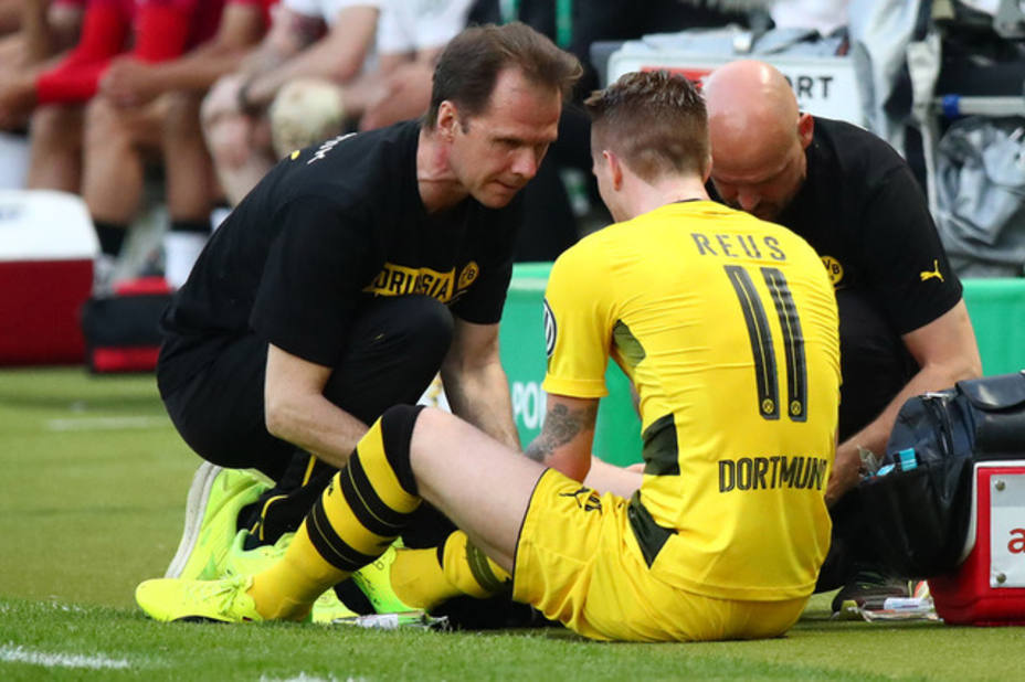 Borussia Dortmunds Marco Reus receives treatment from the physio after sustaining an injury