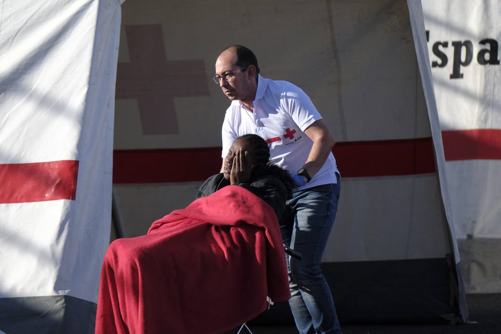 Voluntario de Cruz Roja prestando su ayuda a un migrante