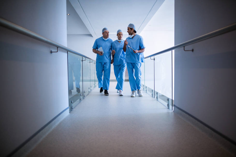 Surgeons interacting with each other in hospital corridor