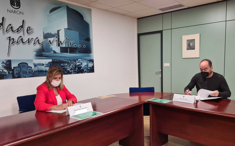 Marián Ferreiro y Jorge López, firmando el acuerdo. FOTO: concello de Narón