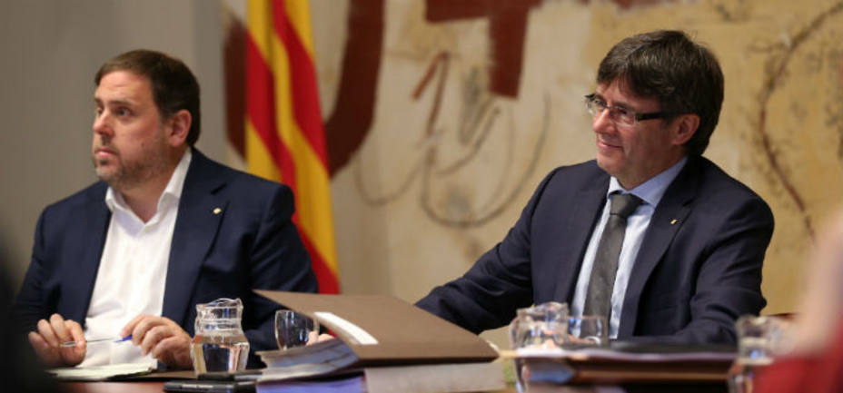 El presidente de la Generalitat, Carles Puigdemont, y su vicepresidente, Oriol Junqueras, durante la reunión semanal del gobierno catalán. EFE