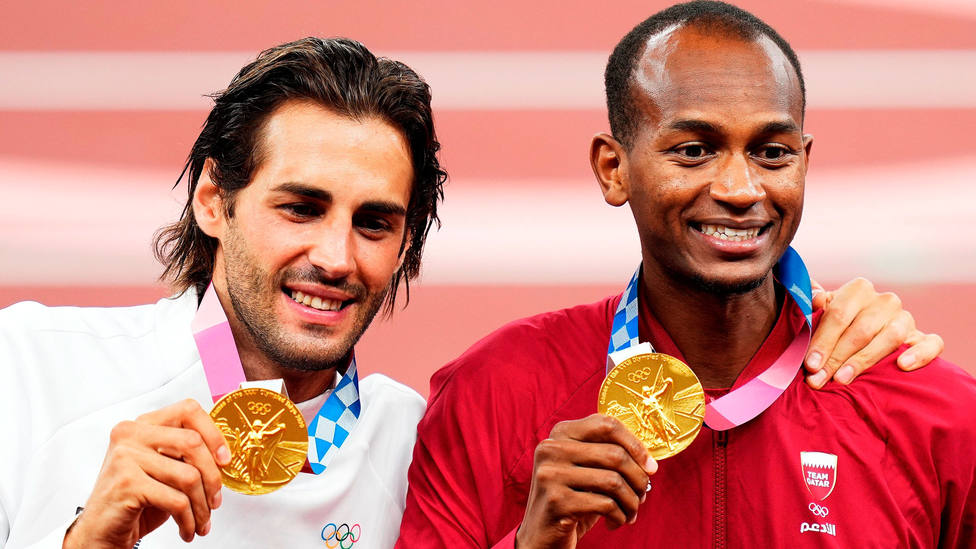 El italiano Gianmarco Tamberi y el catarí Mutaz Essa Barshim celebran juntos el oro en altura sobre el podio