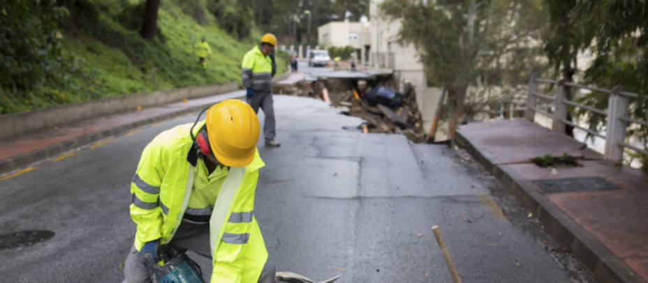 Las intensas lluvias que se han registrado el domingo en Málaga han ocasionado más de doscientas incidencias, sobre todo en la capital. En la foto,un operario trabaja en la calle Flamnecosa tras producirse un desprendimiento de la carretera. EFE
