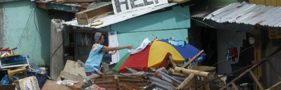 Una mujer se pasea por los restos de su casa en Taclobán (Reuters)