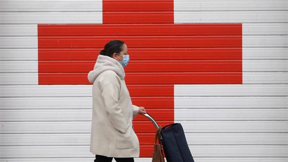 Una mujer pasa frente a la puerta de entrada de ambulancias de la Cruz Roja en Oviedo
