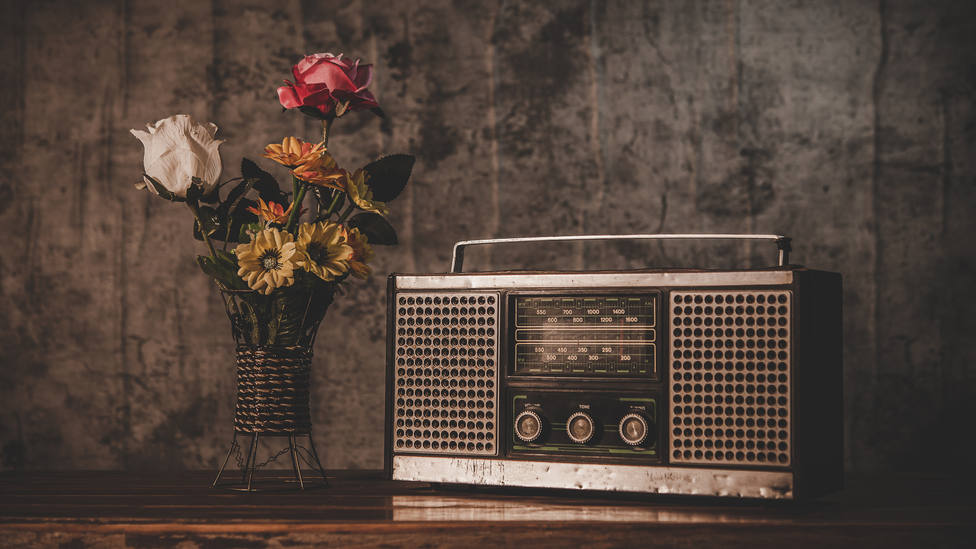 Radio retro junto a un jarrón con flores