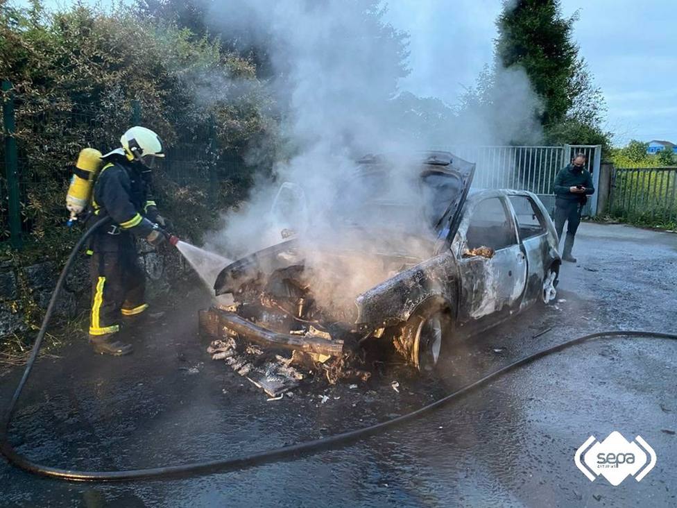 Bomberos apagando el incendio de un vehículo en Lugones