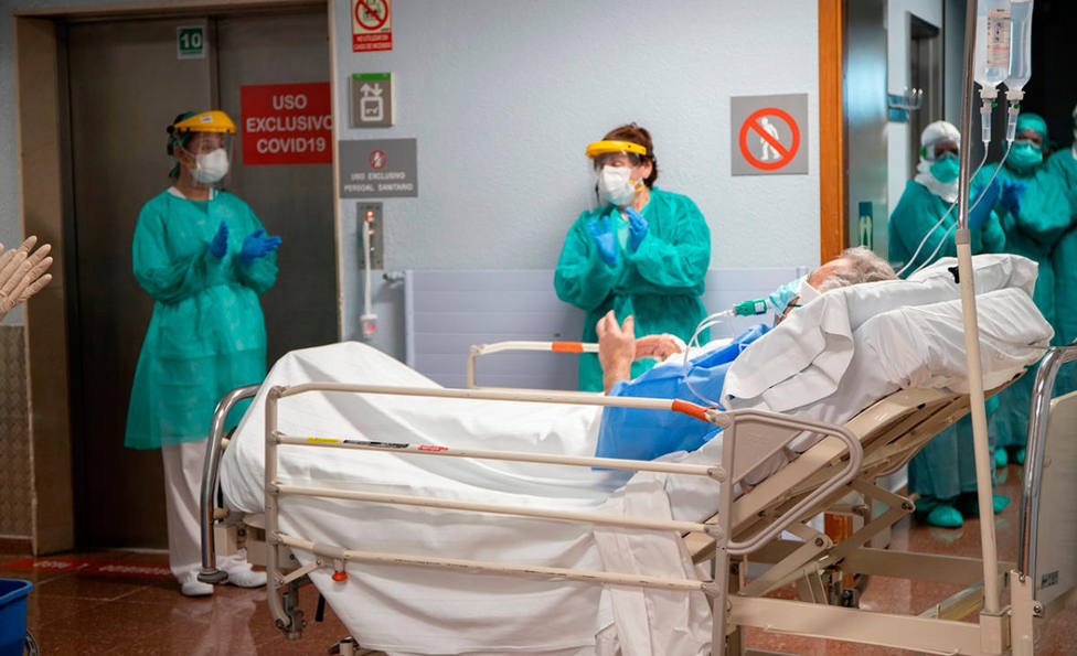 Un paciente recibe una ovación al salir de la UCI en un hospital.